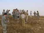 Standing on a hill facing a group, Sgt. Freeman Gardner 